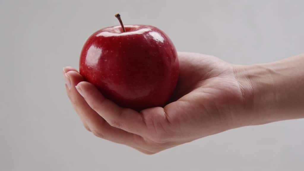 gros plan main tenant pomme rouge brillante