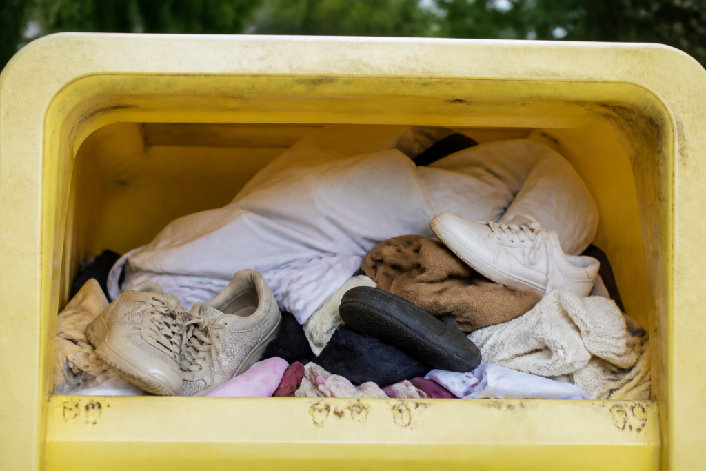 Conteneur jaune de collecte avec chaussures et draps