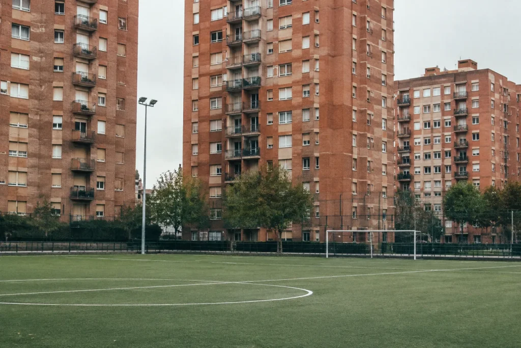 Immeubles de briques hauts près d'un terrain de football