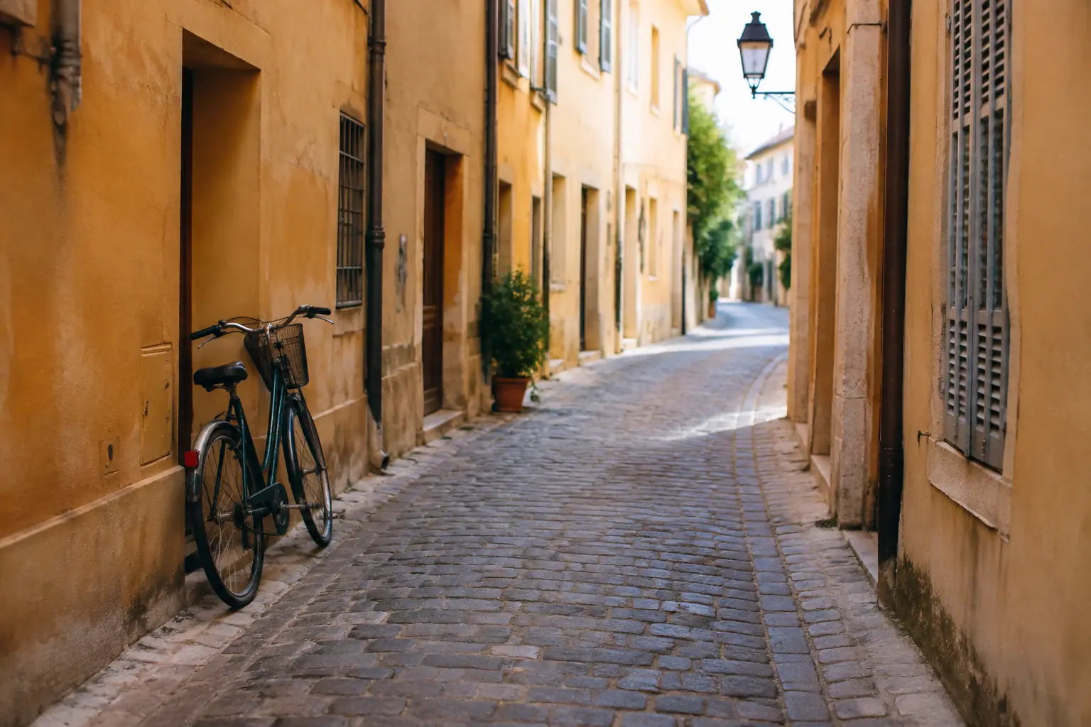 Ruelle pavee bordee de facades ocre, velo appuye