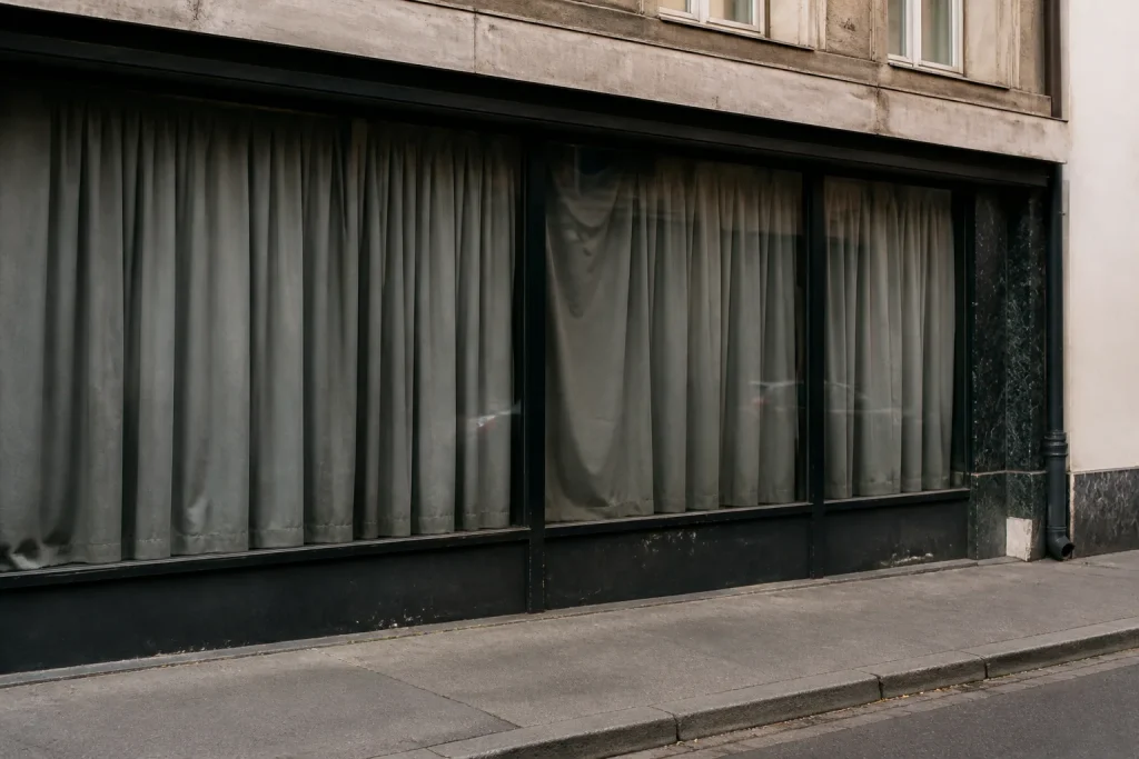 Vitrines vides avec grands rideaux gris dans une rue